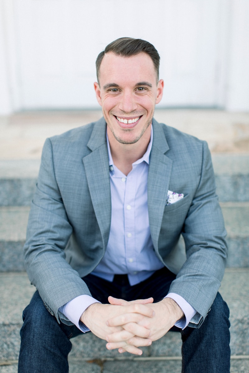 man in gray suit jacket sitting on gray concrete bench providing commercial general liability